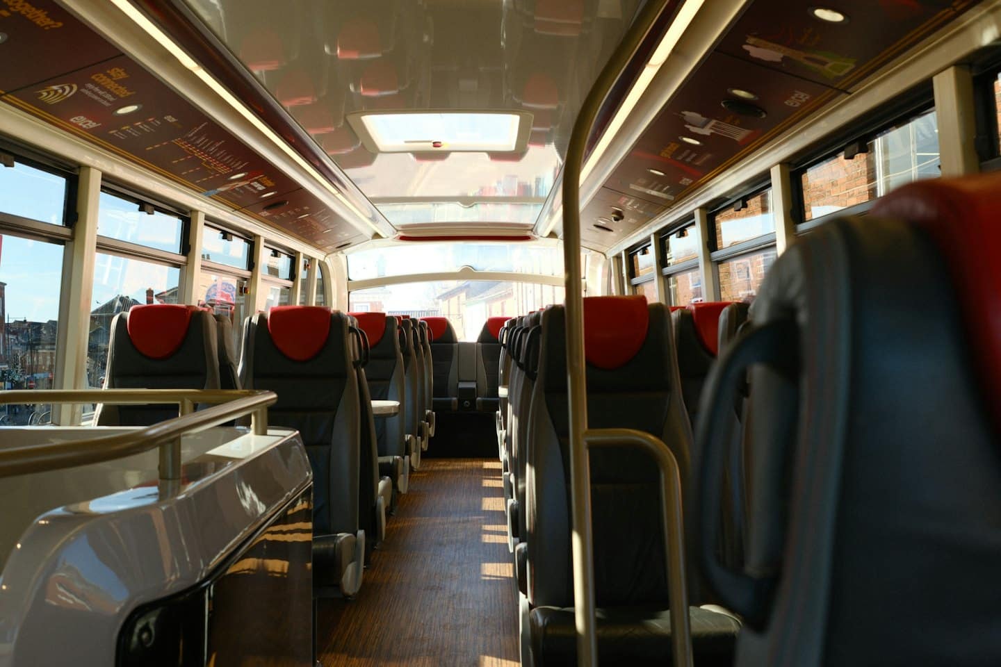 Empty modern bus interior with grey seats and sunny windows.